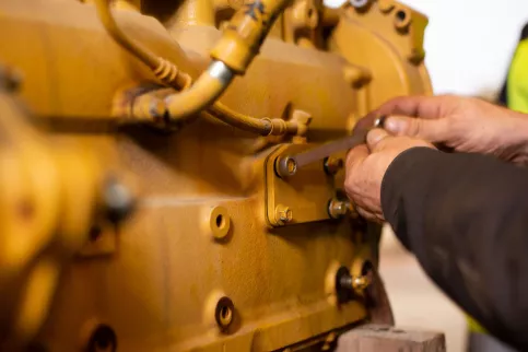 Un ouvrier travaille à la maintenance d'un engin.