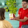 Jeune en formation TCVUJ vendant une plante à une dame